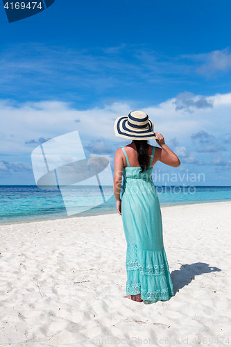 Image of Girl walking along a tropical beach in the Maldives.