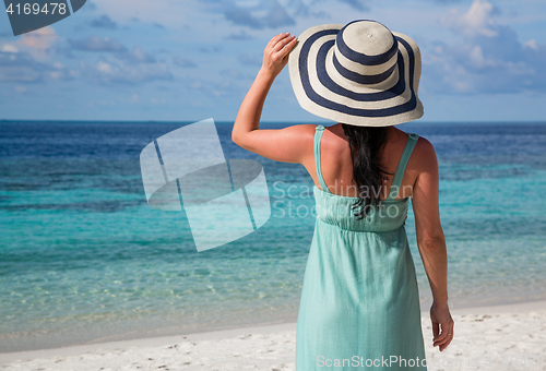 Image of Girl walking along a tropical beach in the Maldives.