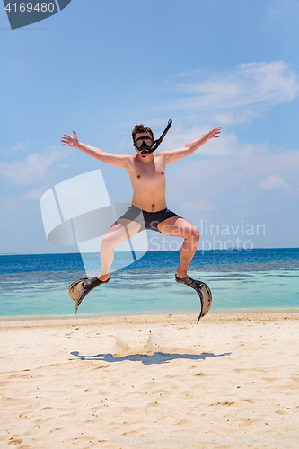 Image of Funny man jumping in flippers and mask.