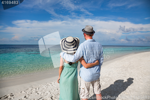 Image of Vacation Couple walking on tropical beach Maldives.