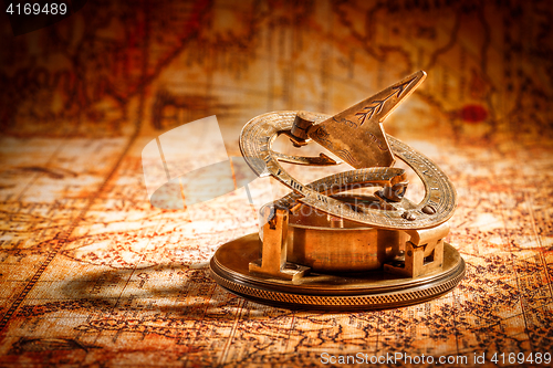 Image of Vintage compass lies on an ancient world map.