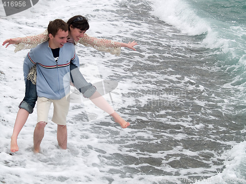 Image of Young Couple Carrying Piggyback on Seashore