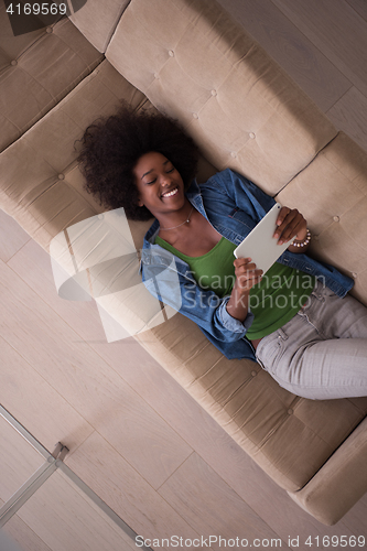 Image of african american woman at home with digital tablet top view