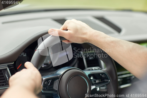 Image of close up of male hands driving car