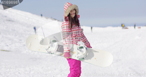 Image of Happy cute female snowboarder on ski slope.