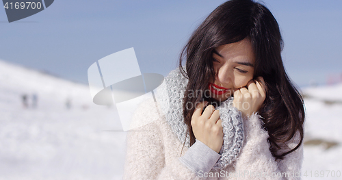 Image of Young woman on ski slope with cozy sweater