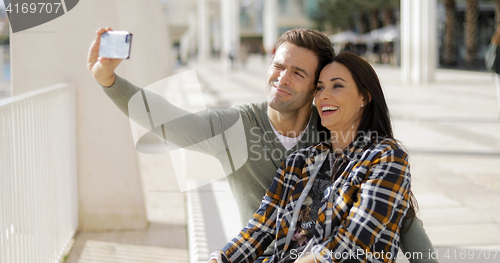 Image of Happy laughing couple taking their selfie