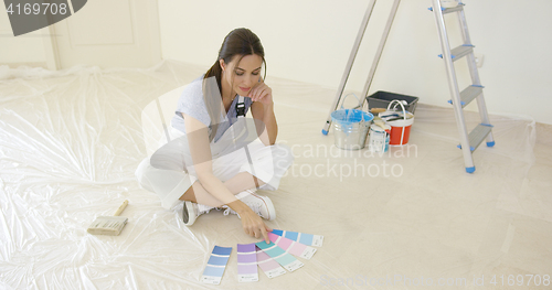 Image of Young woman renovating or decorating her new home