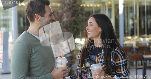 Image of Happy relaxed couple enjoying takeaway coffee