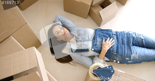 Image of Attractive young woman relaxing on the floor