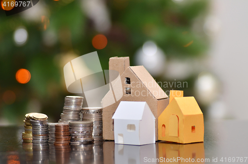 Image of Paper house and stacks of coins standing