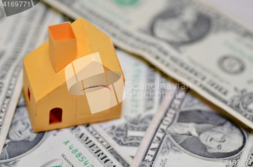 Image of Miniature paper made house stand on  money