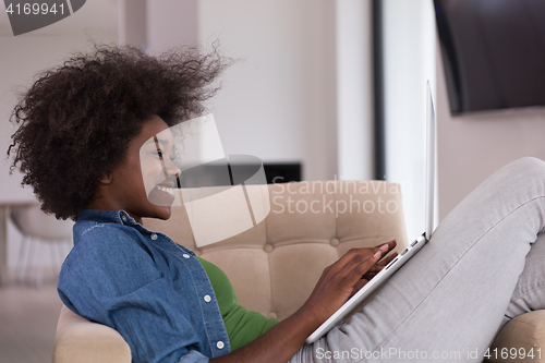 Image of African American women at home in the chair using a laptop