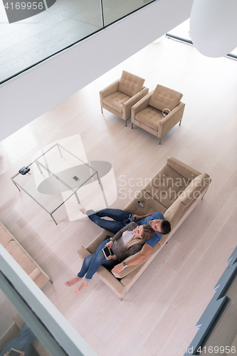 Image of youg couple in living room with tablet top view