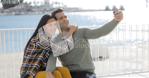 Image of Young couple taking a selfie at the seaside