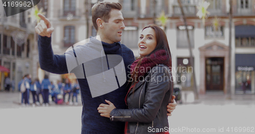 Image of Attractive young man pointing out something