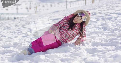 Image of Young woman in pink snowsuit with ski goggles