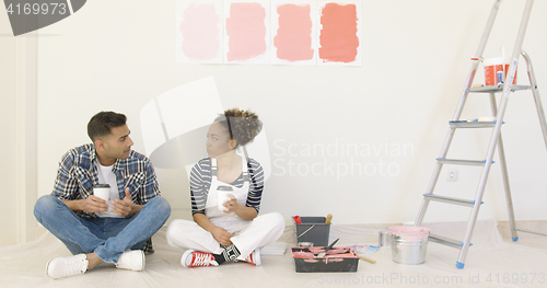 Image of Young couple enjoying coffee while renovating