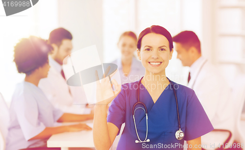 Image of happy doctor over group of medics at hospital