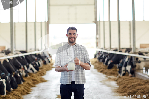 Image of man or farmer with jug of cows milk on dairy farm