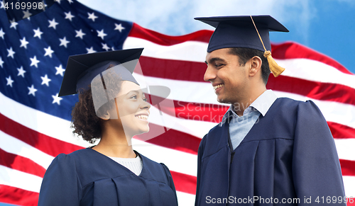 Image of happy students or bachelors in mortar boards