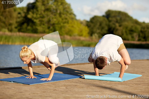 Image of couple making yoga crow pose outdoors