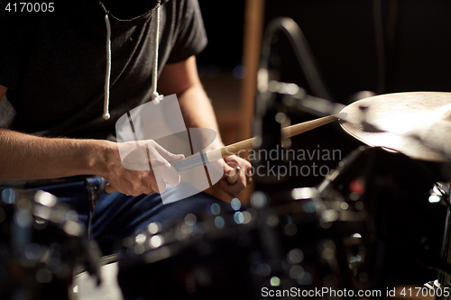 Image of male musician playing drums and cymbals at concert