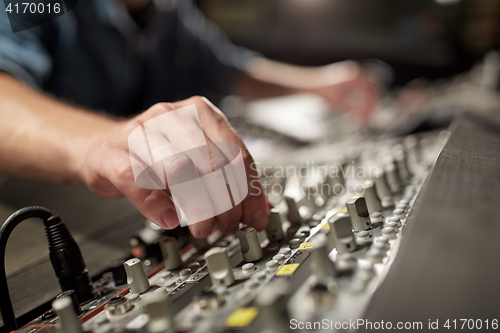 Image of man using mixing console in music recording studio