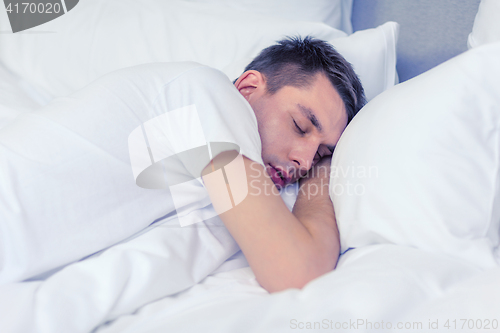 Image of handsome man sleeping in bed