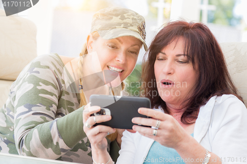 Image of Two Female Friends Laugh While Using A Smart Phone