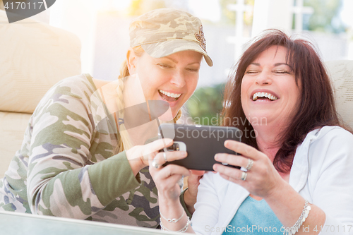 Image of Two Female Friends Laugh While Using A Smart Phone