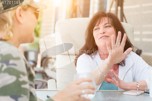 Image of Two Female Friends Enjoying Conversation Outside