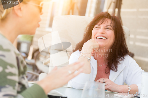 Image of Two Female Friends Enjoying Conversation Outside