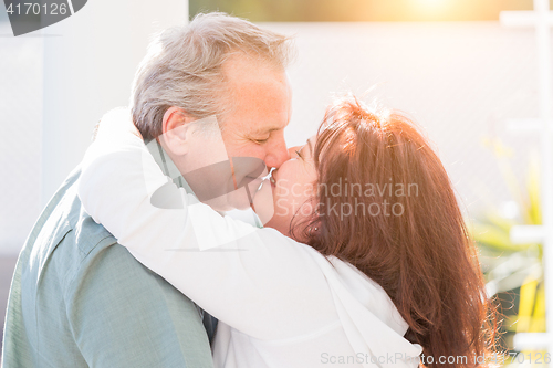 Image of Middle Aged Couple Enjoy A Romantic Slow Dance and Kiss Outside