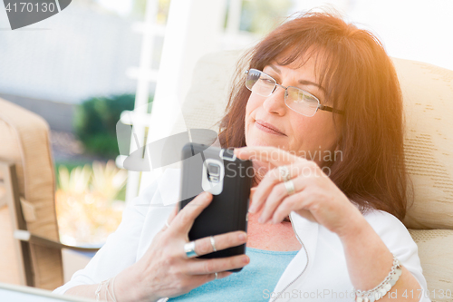 Image of Attractive Middle Aged Woman Using Her Smart Phone