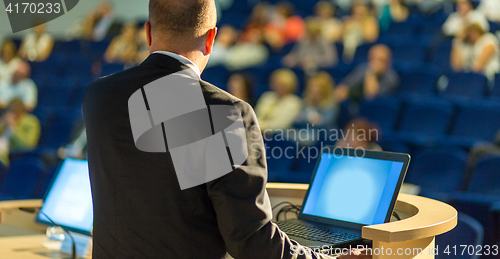 Image of Public speaker giving talk at business event.