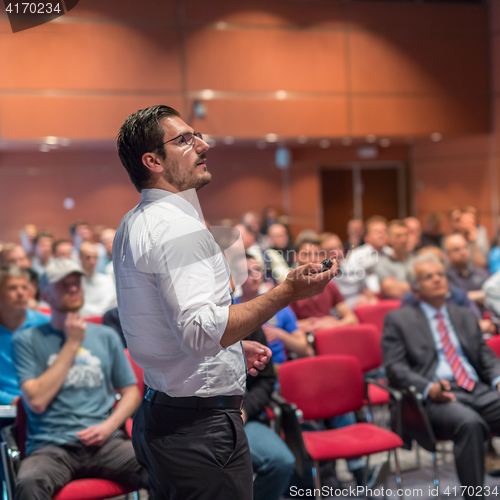 Image of Public speaker giving talk at Business Event.