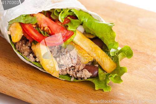 Image of beef burrito with peppers, fried potato and tomato