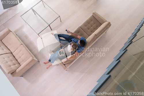 Image of youg couple in living room with tablet top view