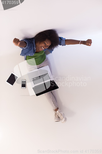 Image of african american woman sitting on floor with laptop top view