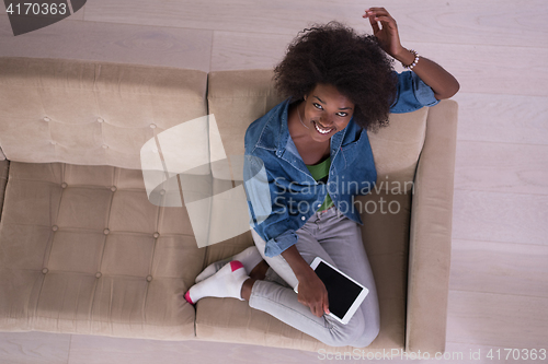 Image of african american woman at home with digital tablet top view