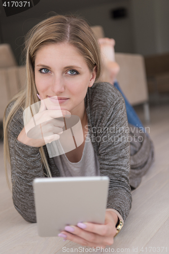 Image of young women used tablet computer on the floor