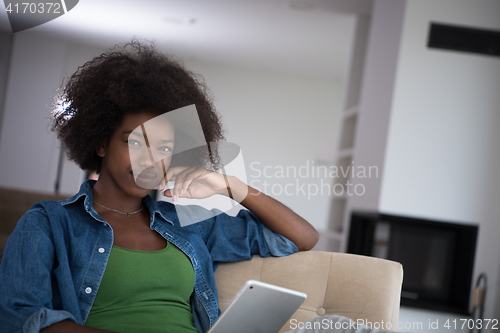 Image of african american woman at home with digital tablet