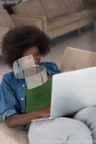 Image of African American women at home in the chair using a laptop