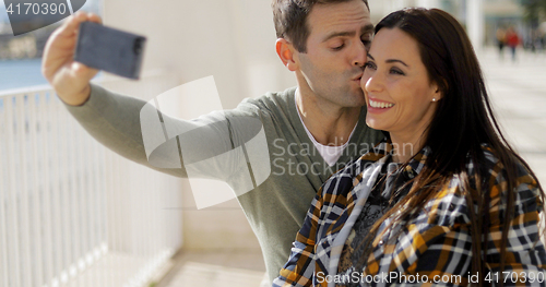 Image of Happy laughing couple taking their selfie