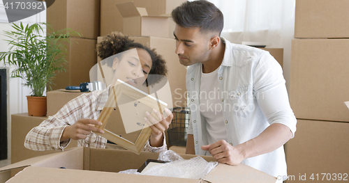 Image of Attractive couple unpacking their things in new home