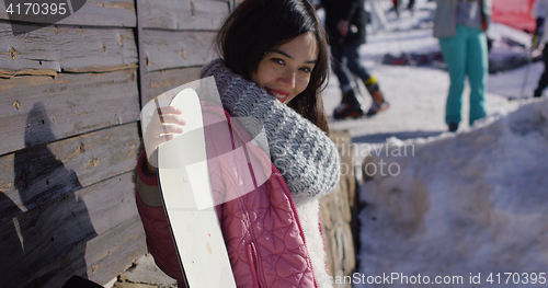 Image of Smiling mixed race girl standing with snowboard