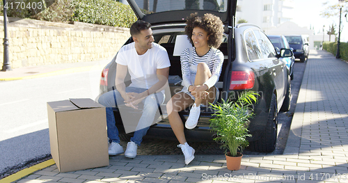 Image of Young couple relaxing while moving house