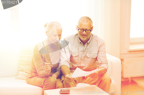 Image of senior couple with papers and calculator at home