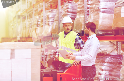 Image of men with tablet pc and forklift at warehouse